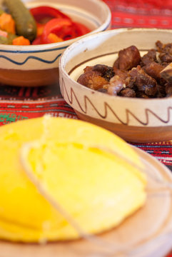 romanian traditional winter season meal with polenta mamaliga fried pork scraps and pickled vegetables