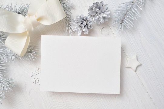 Mockup Christmas Greeting Card With White Tree And Cone, Flatlay On A White Wooden Background, With Place For Your Text