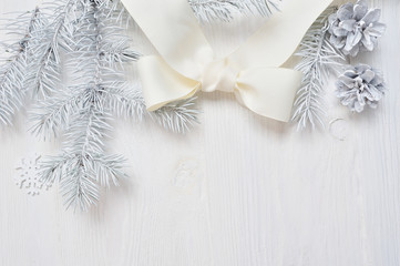 Obraz na płótnie Canvas Mockup Christmas white tree and cone, ribbon bow. Flatlay on a white wooden background, with place for your text