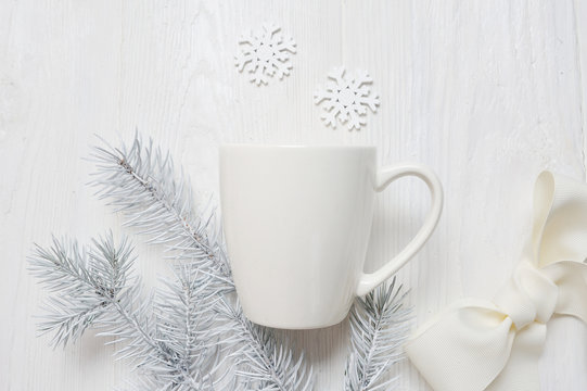 Mockup white cup on a wooden background, in Christmas decorations. The top view is photographed