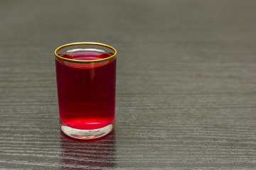 A glass of cherry liqueur on the table.