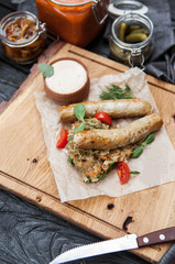 мrustic composition: chicken sausages on a grill with stewed cabbage, mushrooms and a glass of beer on a wooden background