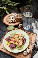 rustic composition: colorful ravioli with mushrooms on a wooden table with a glass of white wine - 184476594