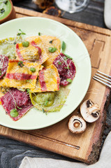 rustic composition: colorful ravioli with mushrooms on a wooden table with a glass of white wine - 184476595