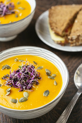 Spicy Squash Soup, gardnished with radish sprouts and pumpkin seeds.