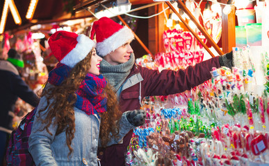 Christmas market shopping, couple choosing things for buying