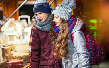 Fototapeta na wymiar Christmas market shopping, couple choosing things for buying