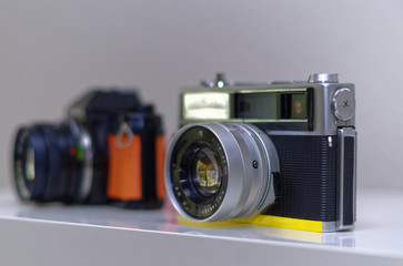 analoge Retro Kamera mit gelbem Sockel Sucherkamera und Spiegelreflexkamera in orange 