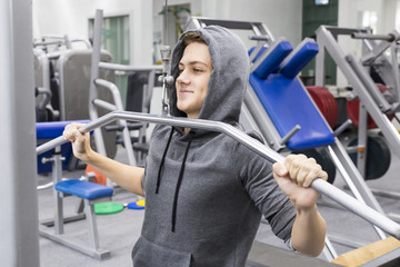 The teenager is engaged in power fitness in the gym.