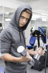 The teenager is engaged in power fitness in the gym.