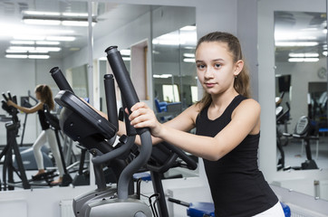 Fototapeta premium Girl is engaged in sports and gymnastics in the gym 