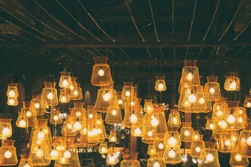 Bright lights of lamps on the ceiling in the restaurant. Lamps in the fishing net. Fashionable...