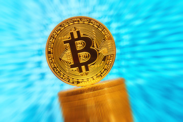Golden bitcoin are stacked on a bright blue background. Bitcoin cryptocurrency. Anonymous