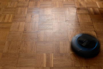 Fototapeta na wymiar Robovac cleaning wooden floor