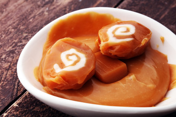 caramel candies and caramel sauce isolated  in white bowl.