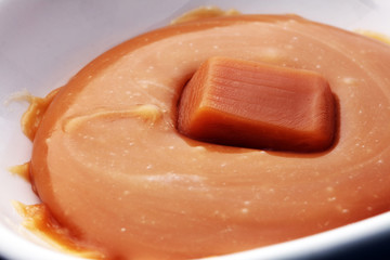 caramel candies and caramel sauce isolated  in white bowl.