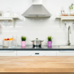 A wooden table top of the kitchen table on a blurry background of the kitchen interior. Bright interior decoration of home cooking. Bright ready-made picture for your individual design - 184482338