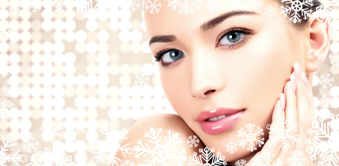 Pretty woman against an abstract background with circles and snowflakes. Winter skin treatment...