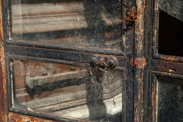 Wooden Coffin behind glass and metal door with spider web