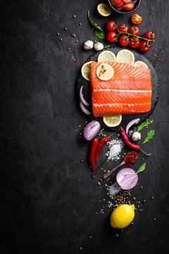 Fresh raw salmon red fish fillet on black background. Top view