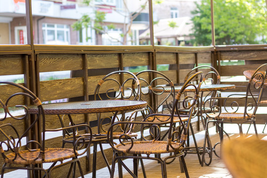 Cosy terrace of the summer cafe with wicker tables and chairs