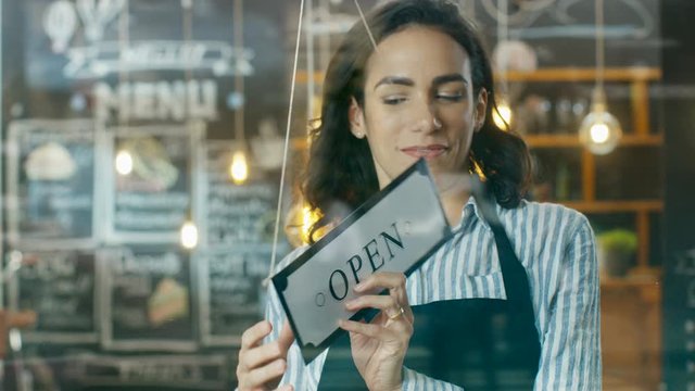 Beautiful Young Cafe Owner Turning Storefront Sign From Close to Open and Welcoming Her New Customers into Her Modern Looking Stylish Coffee Shop. Shot on RED EPIC-W 8K Helium Cinema Camera.