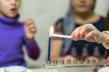 Girl lights Chanukah candles