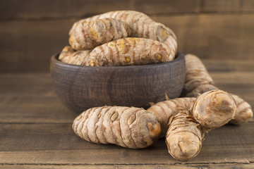 Turmeric roots on the wooden background