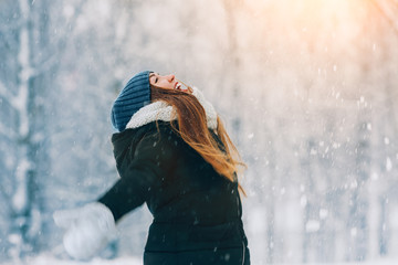 Winter young woman portrait. Beauty Joyful Model Girl laughing and having fun in winter park. Beautiful young woman outdoors. Enjoying nature, wintertime