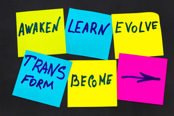 awaken, learn, evolve, transform and become - inspirational new year goals or resolutions - colorful sticky notes on a blackboard