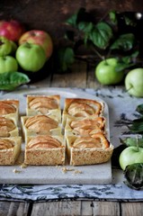 On the stand is a curd cake with apples, in slices. Fresh apples