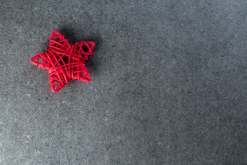 Red Christmas star at dark textured background with empty space for text, mockup. Eve and Happy new year theme
