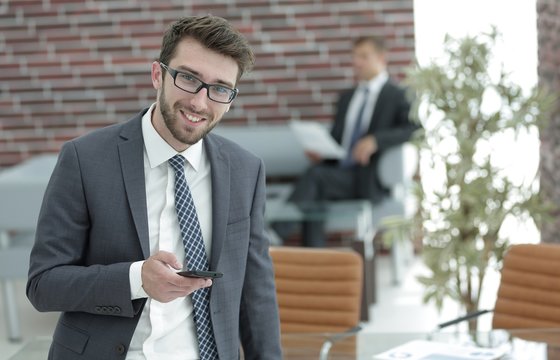 businessman with smartphone on blurred background office