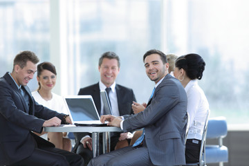 group of smiling business people sitting in a meeting room.