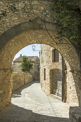 Stone archway and buildings in the ancient town of Vertine, in Tuscany, Italy