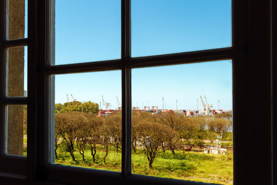 Port with containers and cranes seen through a window