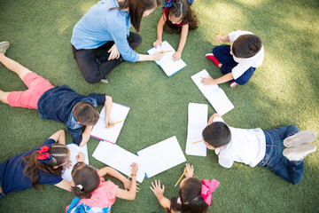 Top view of preschool students learning and taking a class outdoors