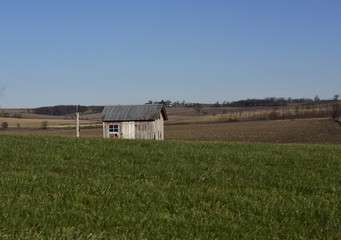 old shed on farmland in field