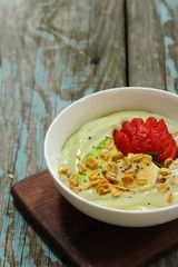 Avocado Smoothie Breakfast bowl with granola chia banana and strawberry, selective focus