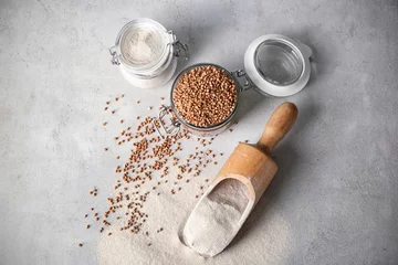  Kitchenware with buckwheat flour and raw grains on table © Africa Studio