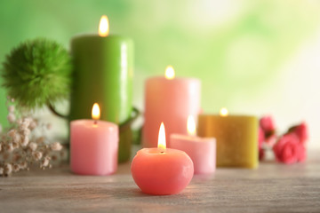 Fototapeta na wymiar Wax candles burning on table against blurred background, closeup