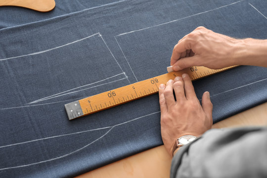 Young tailor working with textile, closeup