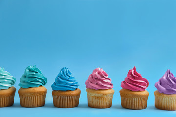 Delicious cupcakes on color background