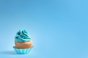 Delicious cupcake on color background