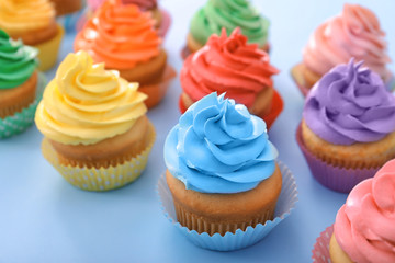 Delicious cupcakes on color background