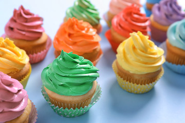 Delicious cupcakes on color background
