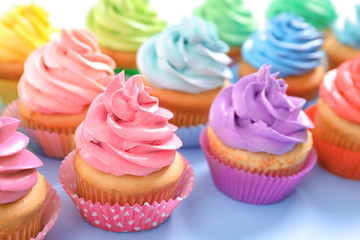 Delicious cupcakes on color background