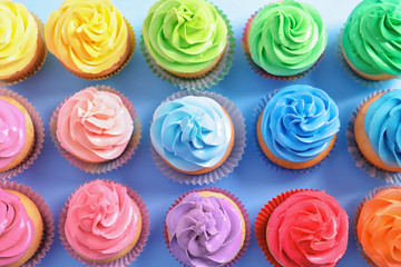 Delicious cupcakes on color background, top view
