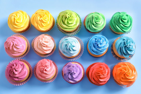 Delicious cupcakes on color background, top view