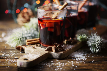Christmas hot mulled wine with cinnamon cardamom and anise on wooden background, selective focus